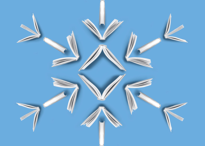 A view from above of opened books arranged to create the shape of a snowflake.
