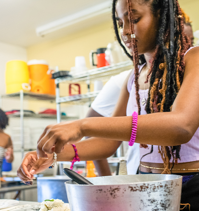 A young woman cooking in an industrial kitchen