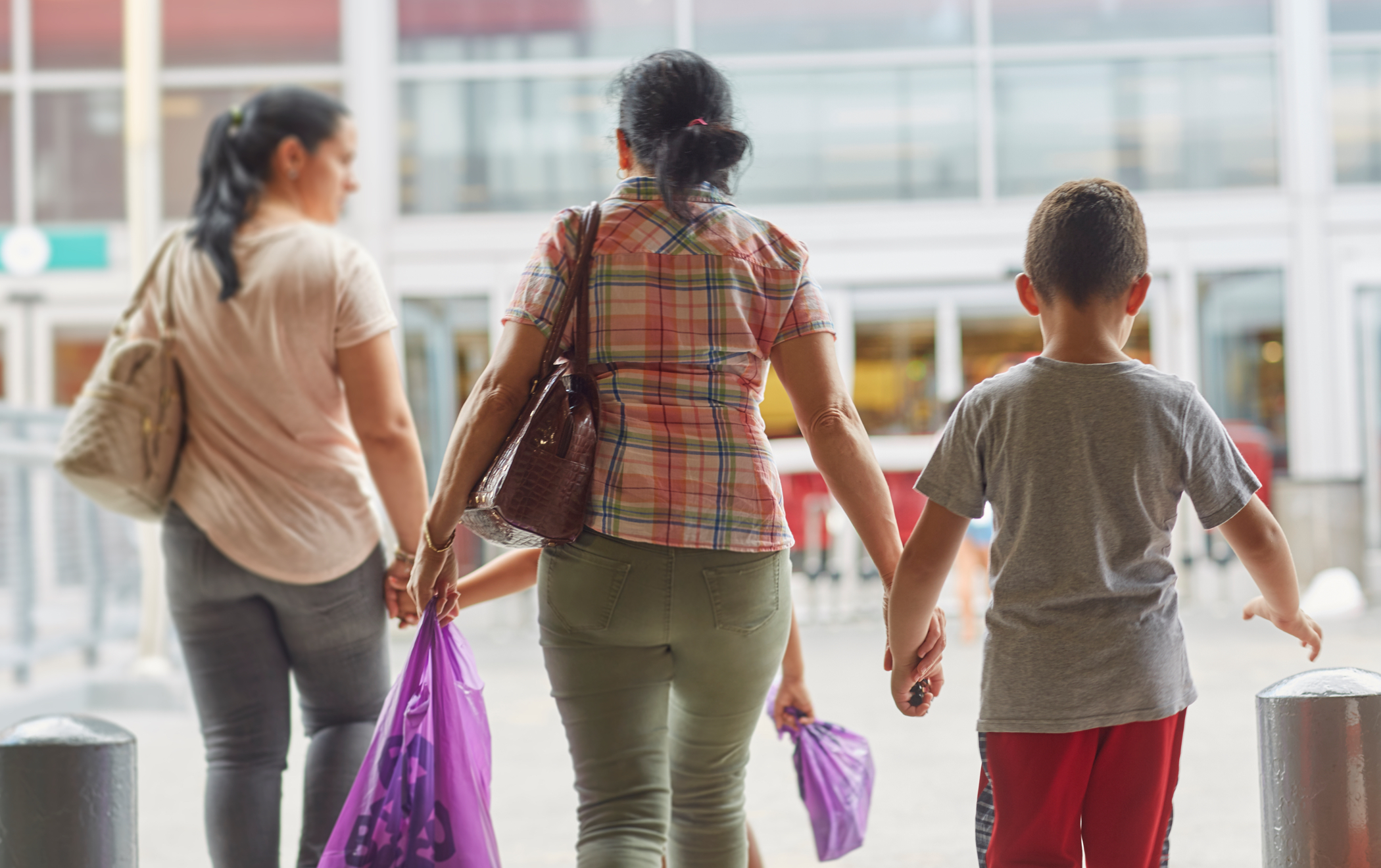 A view from behind of a family exiting the Bronx Terminal Market hand in hand.