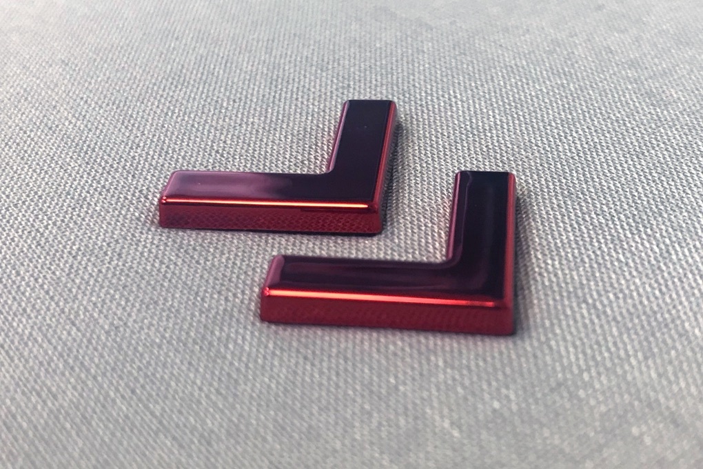 Close up of the 3D red metallic Instinet brand chevron symbols on the Fintech at Fifty graphic novel linen box case.