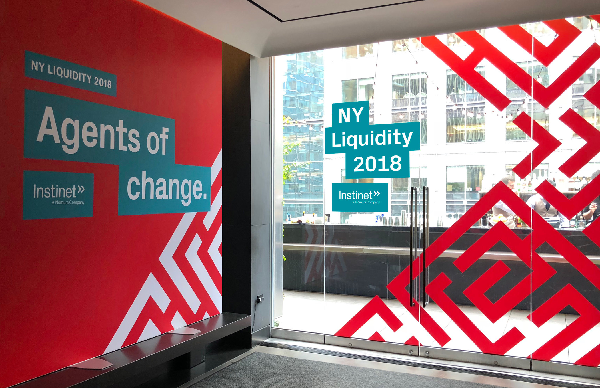 Wall and window signs with red maze patterns at an Instinet client event titled Agents of Changed.