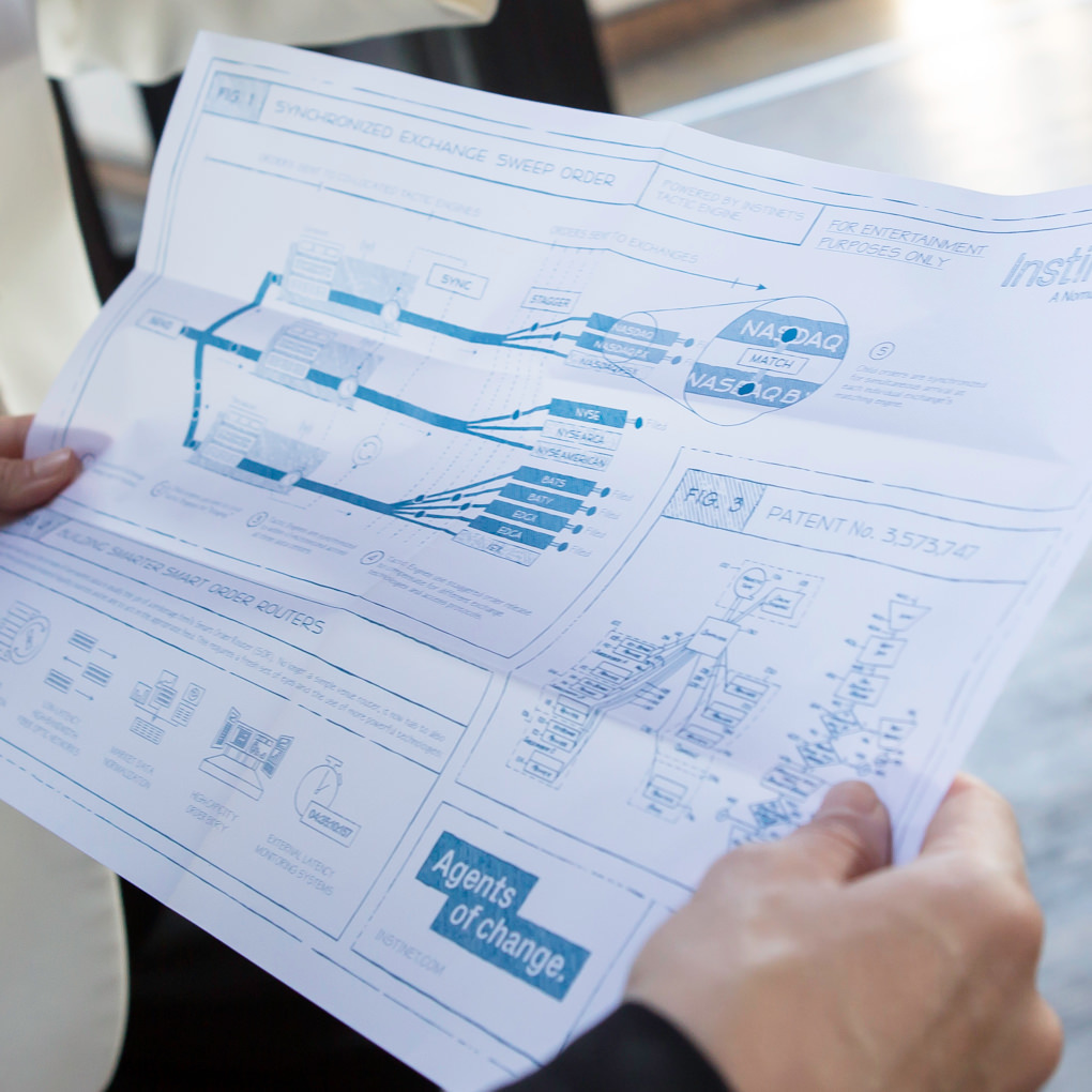 A close up of a someone holding a sheet with diagram of various Instinet trading technologies at a client event.