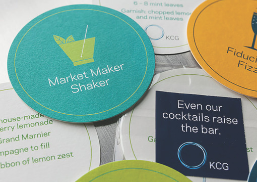 Custom drink coasters from the 2014 KCG Uncon client event with the slogans 'Market Maker Shaker," and "Fiduciary Fizz."