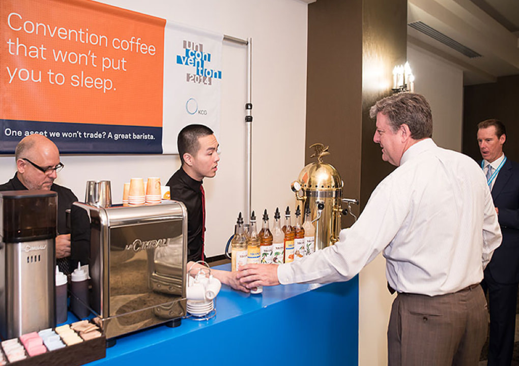 A 2014 KCG Uncon client event attendee grabs a coffee from the refreshment station during a conference break.
