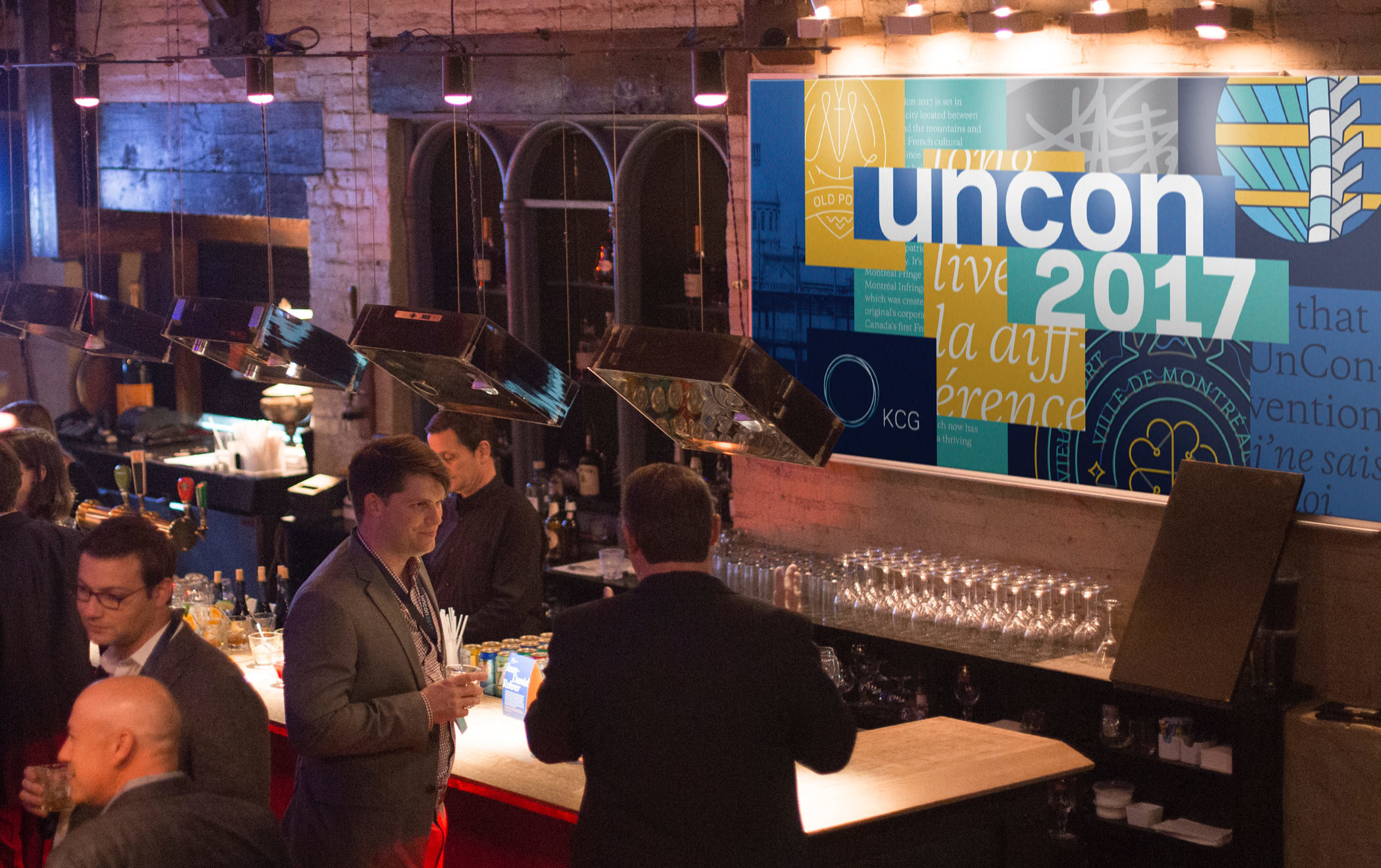 Attendees enjoying drinks near the bar during a cocktail reception at the 2017 KCG Uncon client event.