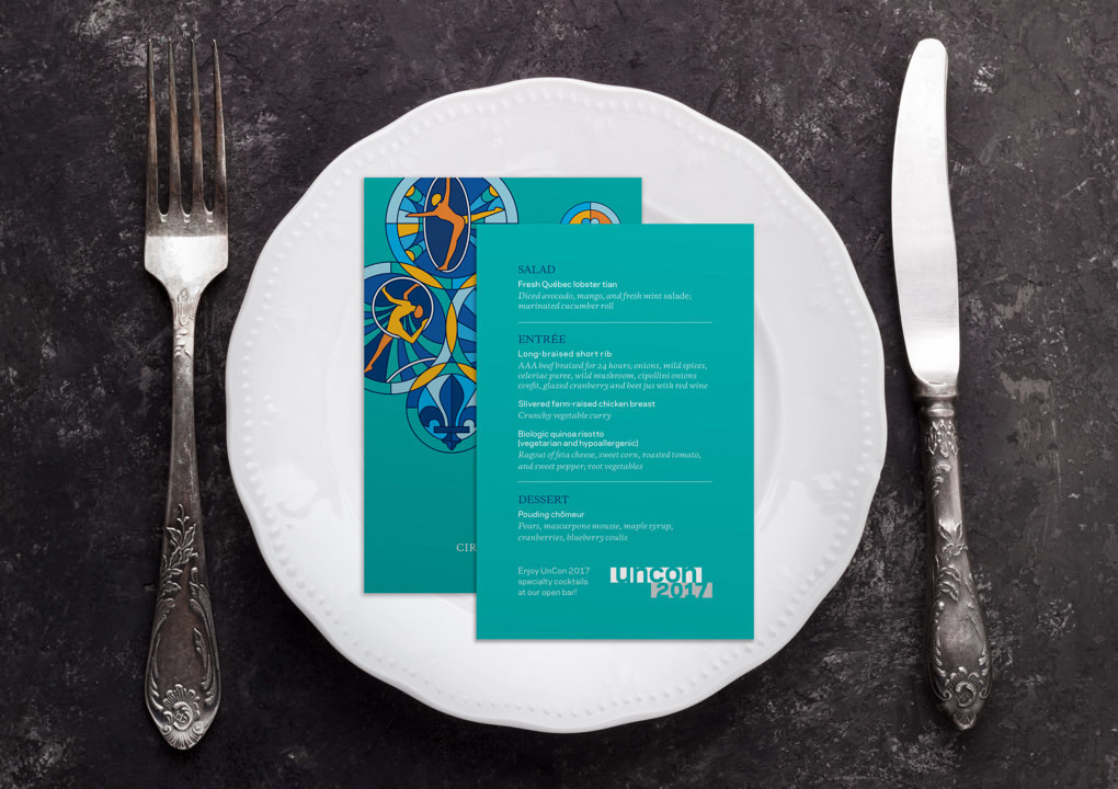 A place setting with a knife, fork, plate, and illustrated menu cards for a dinner at the 2017 KCG Uncon client event.