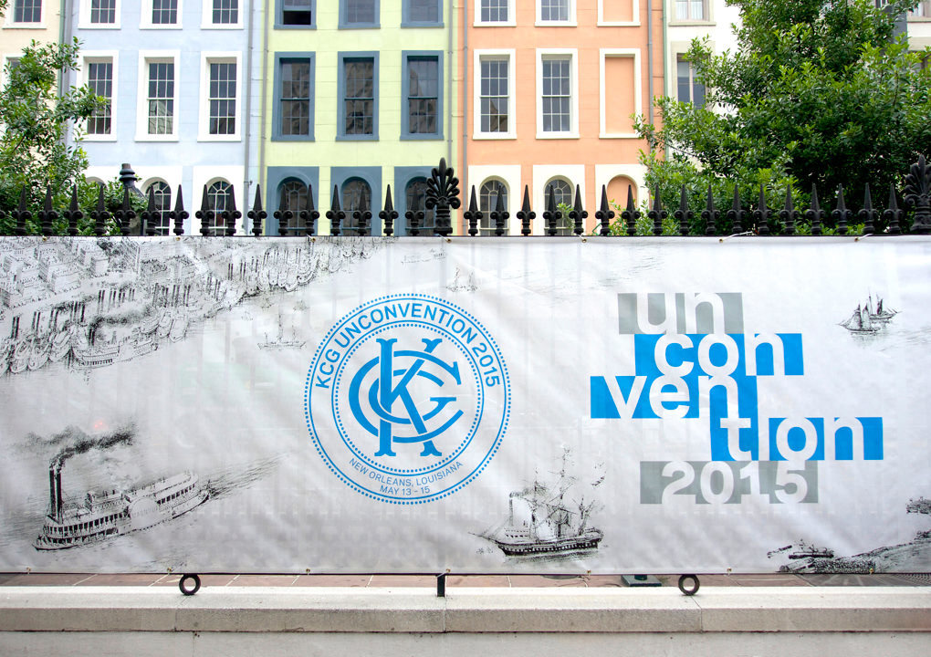 A mural on a fabric banner attached to an ion fence with the 2015 KCG Uncon client event logo and title