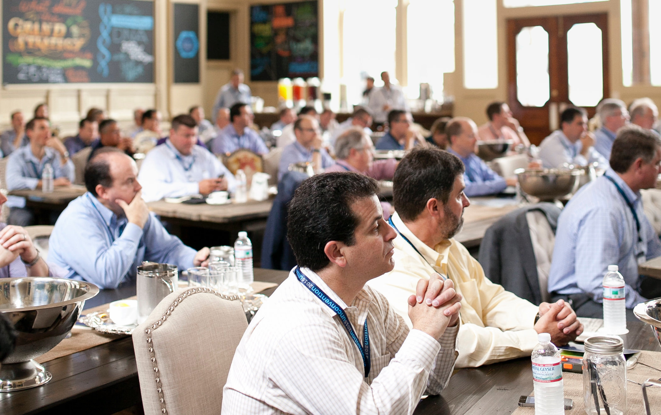 A large group of 2015 KCG Uncon client event attendees listen to an event presentation.
