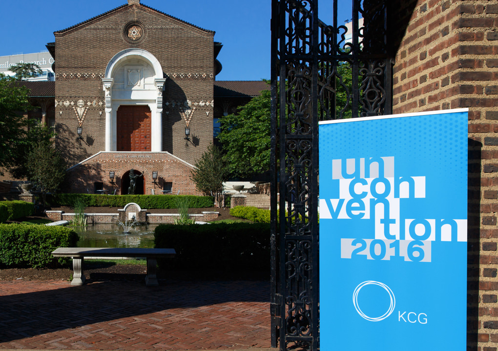 KCG Uncon 2016 client event banner at the entrance gate of a grand building and courtyard.