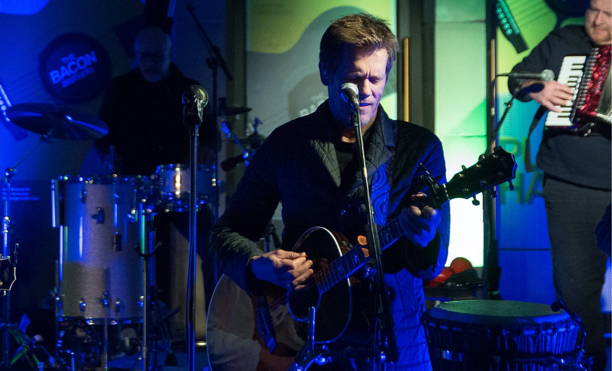 A photo of the Bacon Bros. performing live with their guitars.