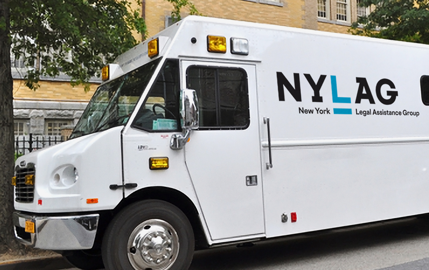 A parked white mobile truck displaying the new New York Legal Assistance Group logo.