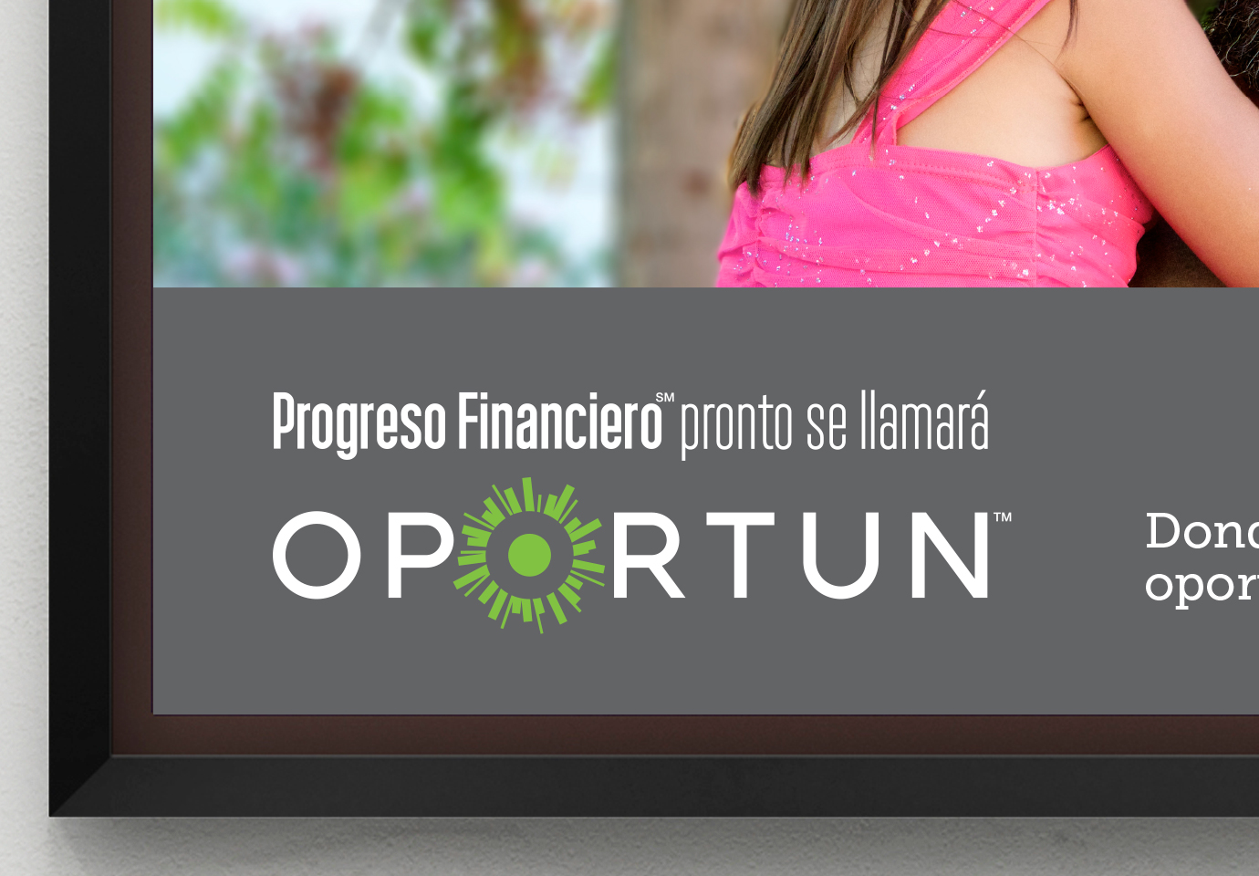 Cropped view framed wall poster with the Oportun logo and the Spanish phrase, "Progreso Financiero pronto se llamará."