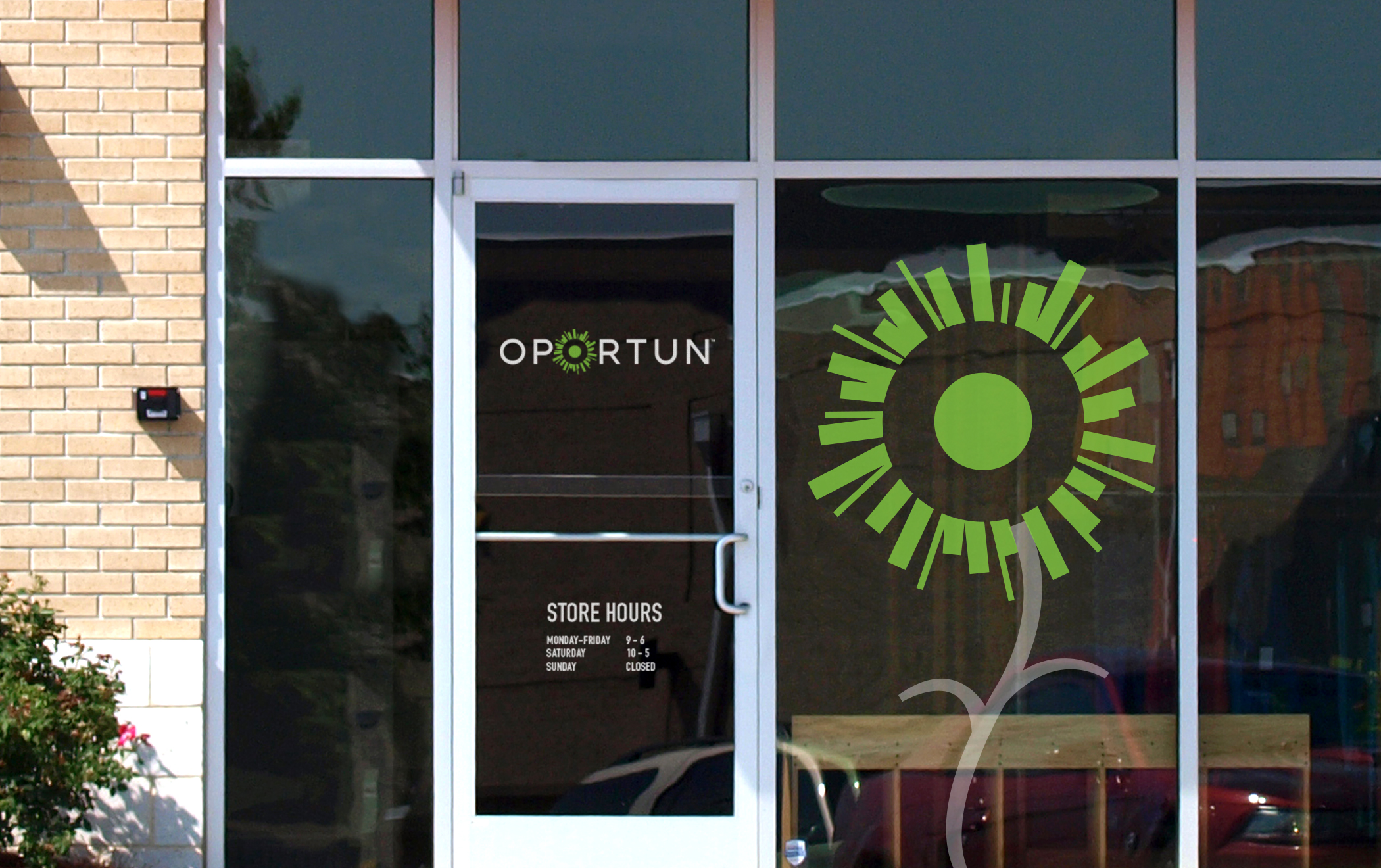 The Oportun logotype and large green-sun symbol on the window of a storefront.