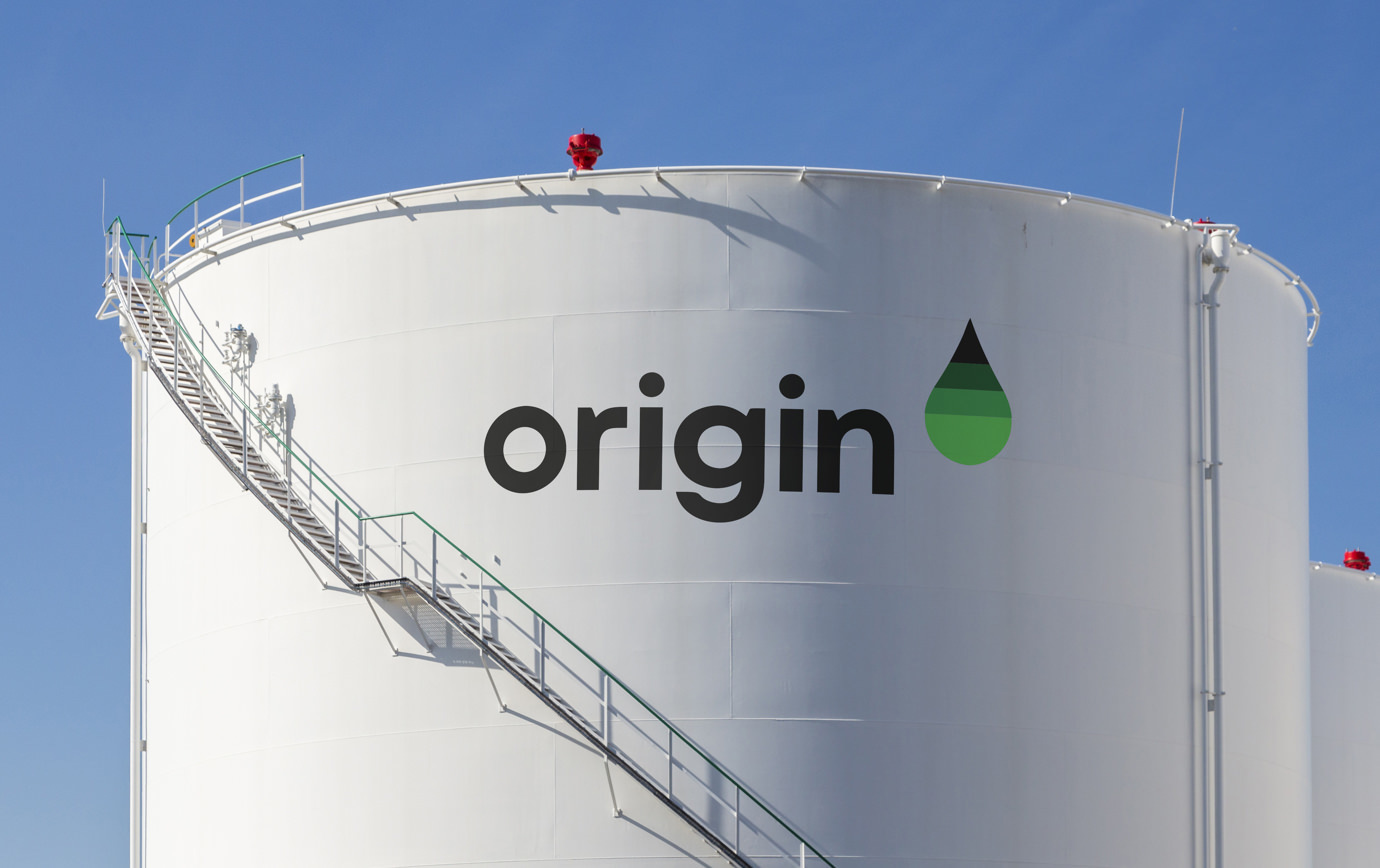 The Origin International logotype and green-gradient droplet symbol painted on a large white holding tank.