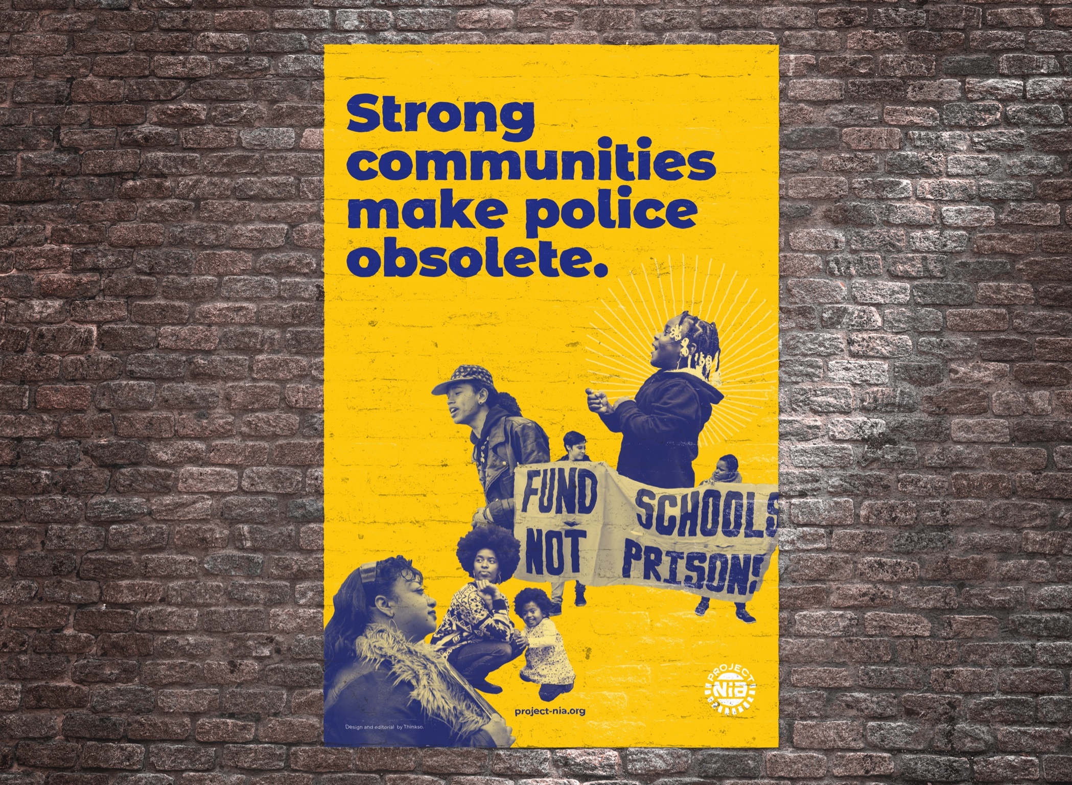 A Project Nia poster on a brick wall that reads "Strong communities make the police obsolete" with images of protesters.