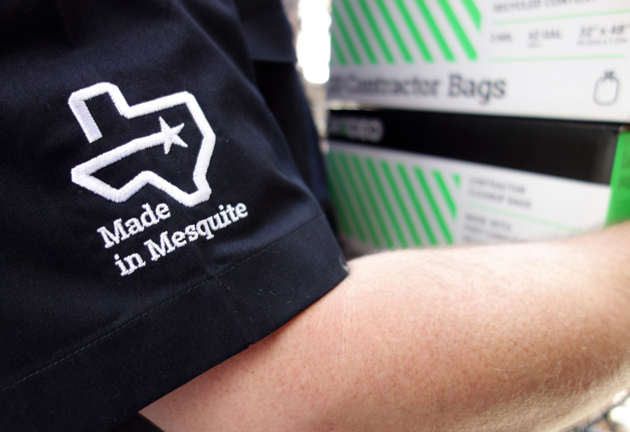 Close up of emroidery on a Rodeo Plastics tee shirt with a outline of the State of Texas and the phrase "Made in Mesquite."