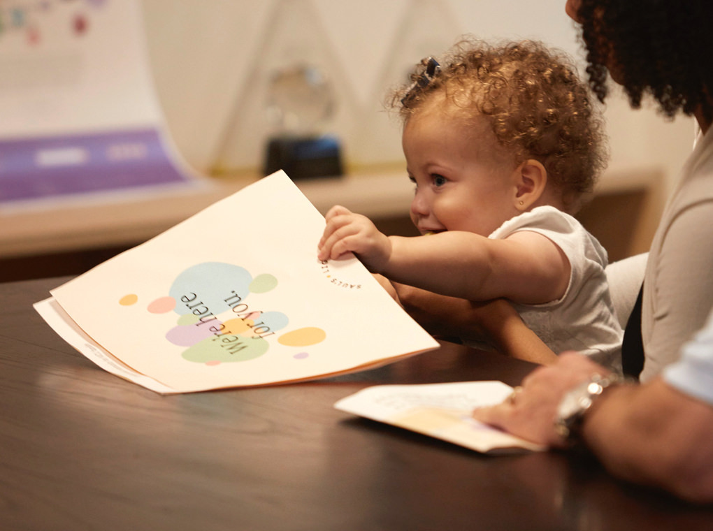 The infant child of the Saul's Light founders playing with a design sketch in the Thinkso conference room.