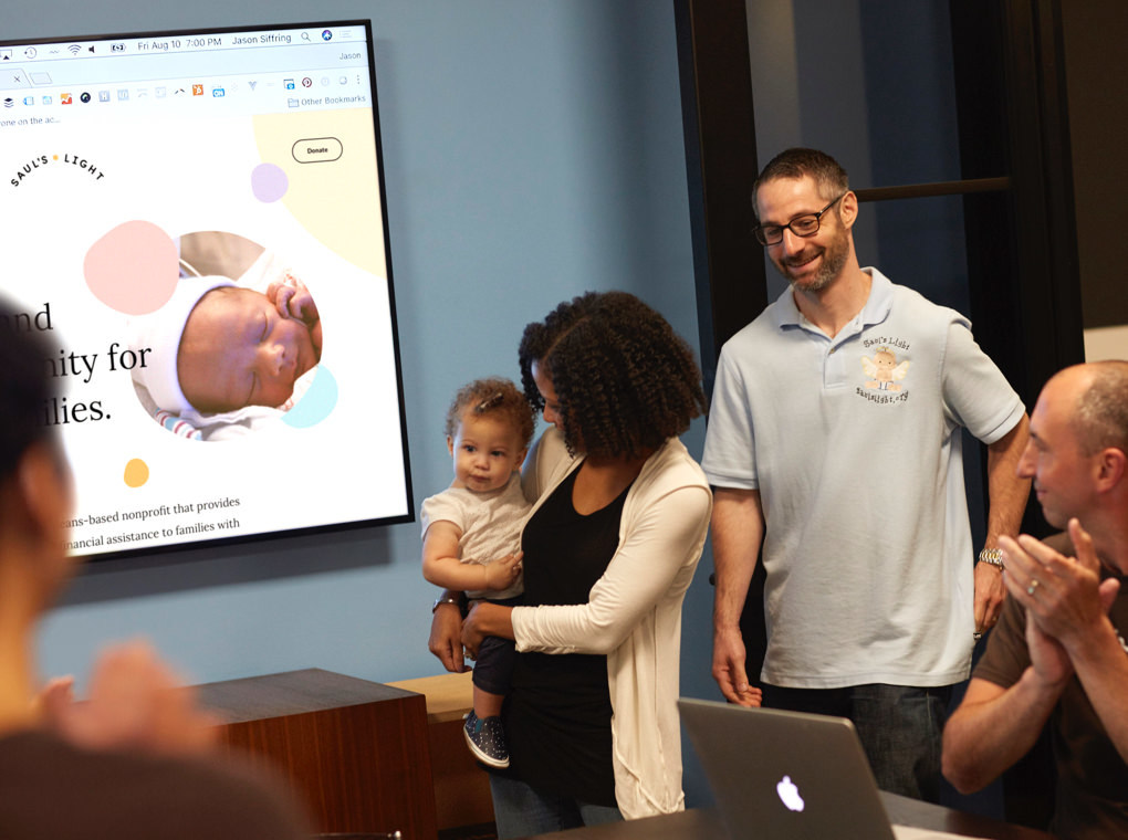 Saul's Light founding couple and child viewing work during the Thinkso 2018 Give a brand design sprint.
