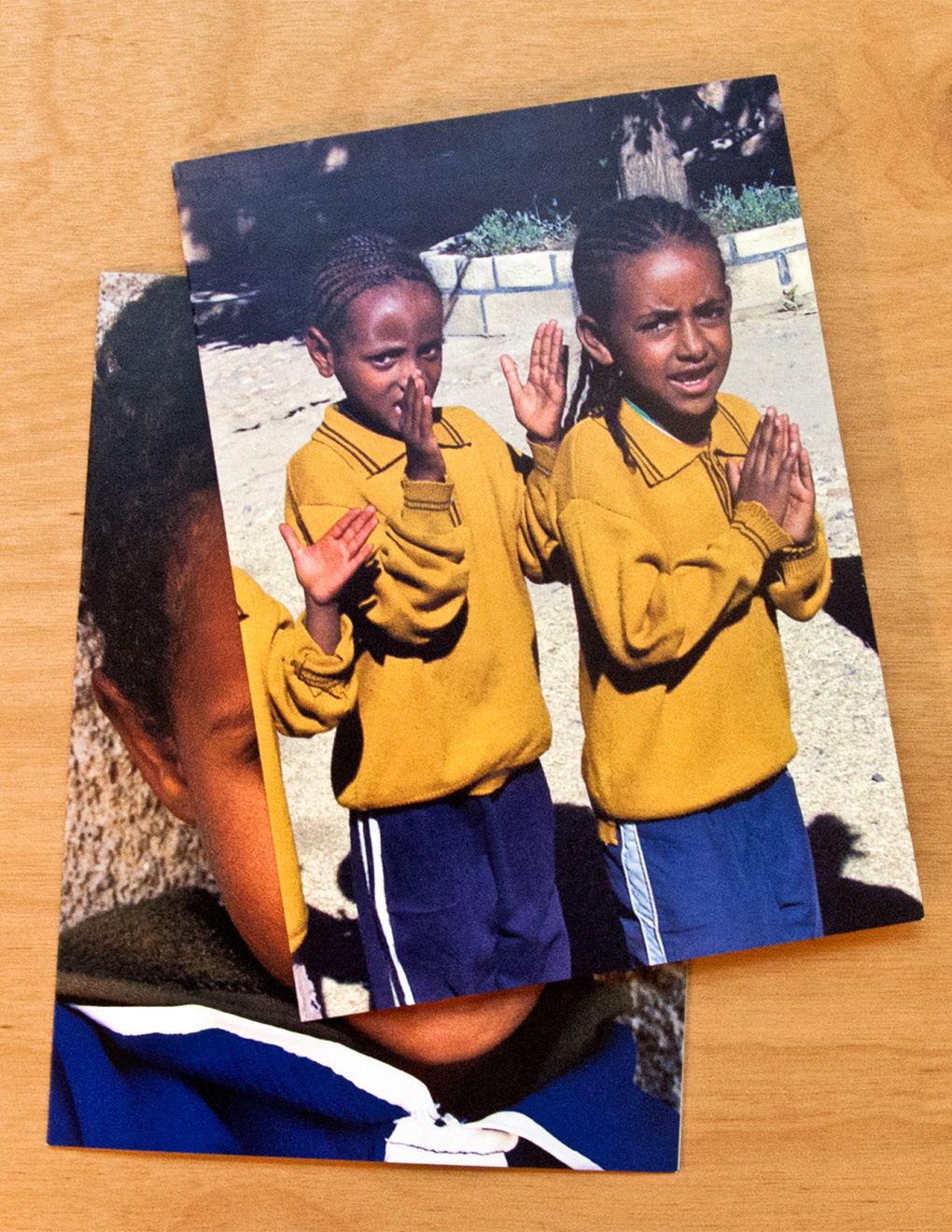 Two children in matching yellow sweaters clapping and singing.