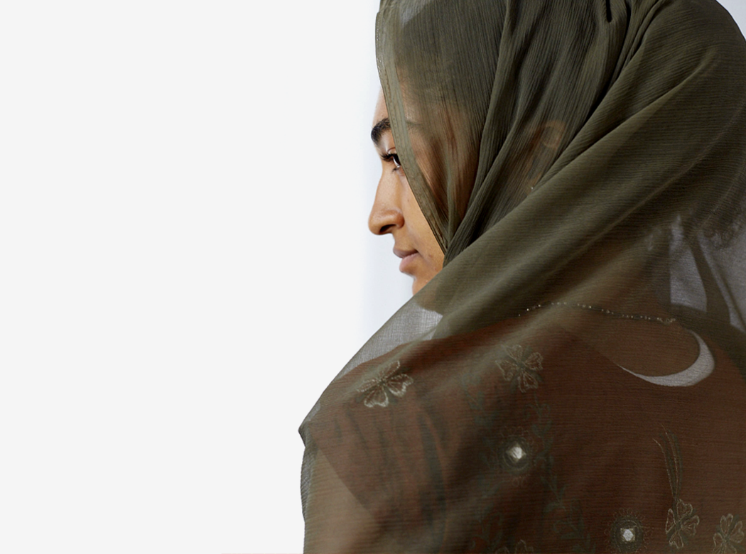 An example of Think Responsive brand photography: an over-the-shoulder rear view of a figure wearing a green head scarf.