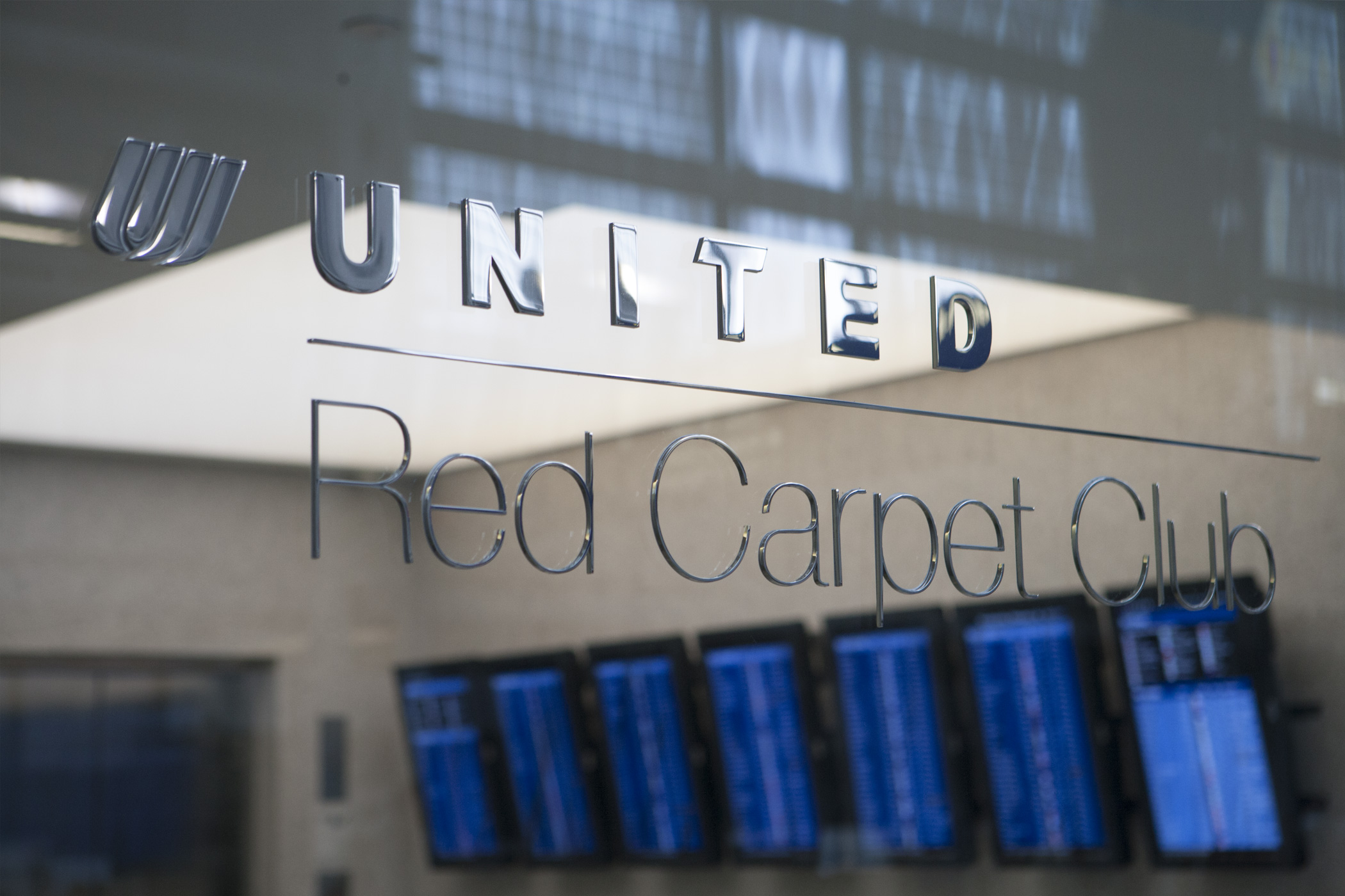 United Airlines Red Carpet Club signage in a glass partition.