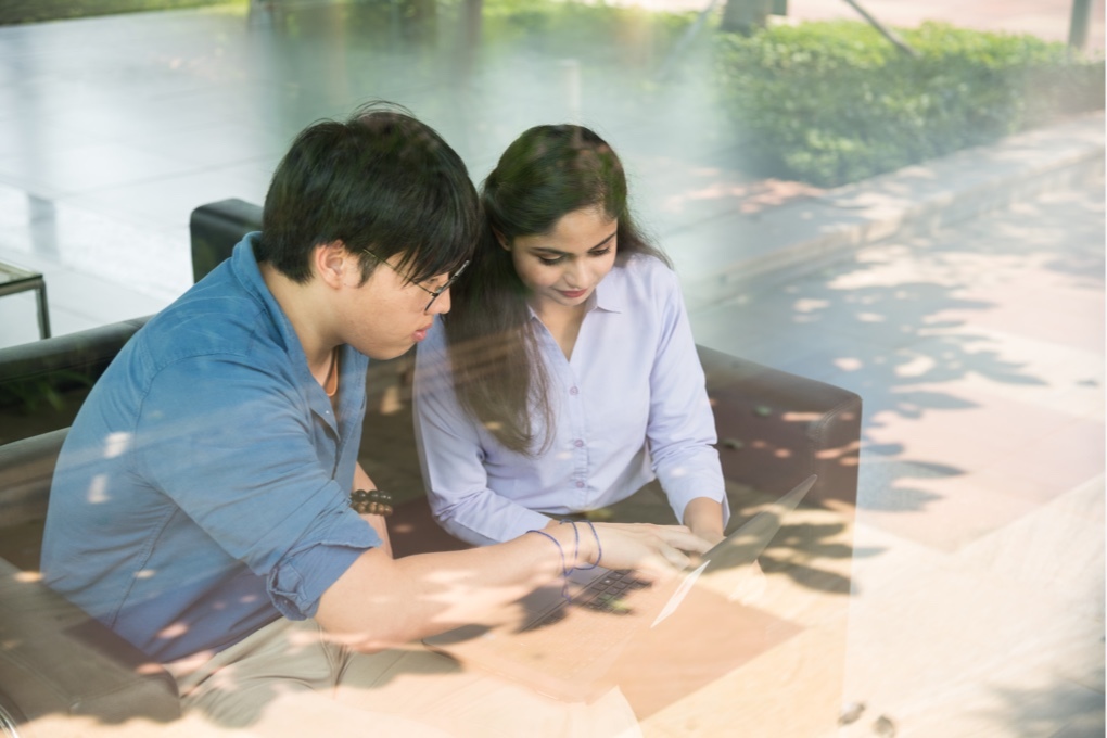 Two Mindtree employees collaborate on laptop