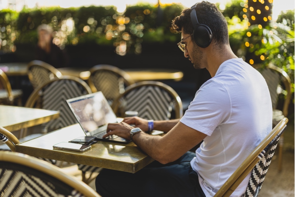 Man working on laptop at outside cafe