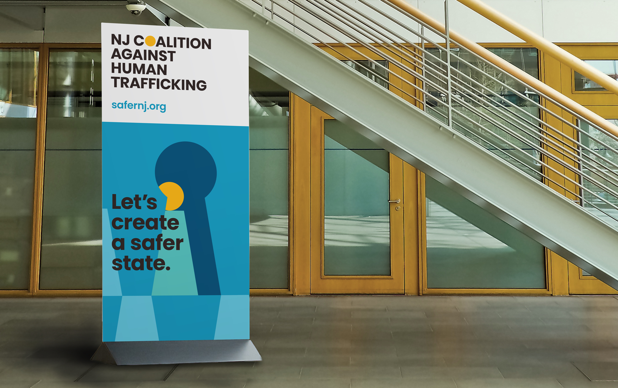 Pull-up banner with NJ Coalition Against Human Trafficking branding reads “Let’s create a safer state. safernj.org”