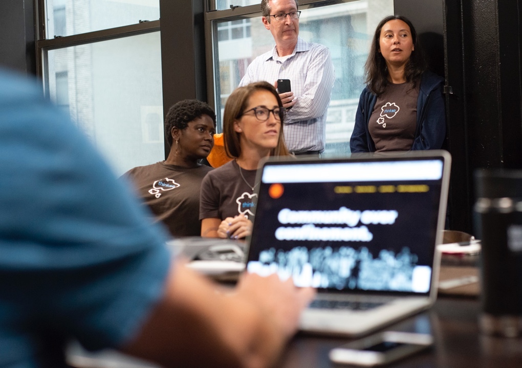 Members of the Thinkso team and Project Nia board work together in the Thinkso conference room.