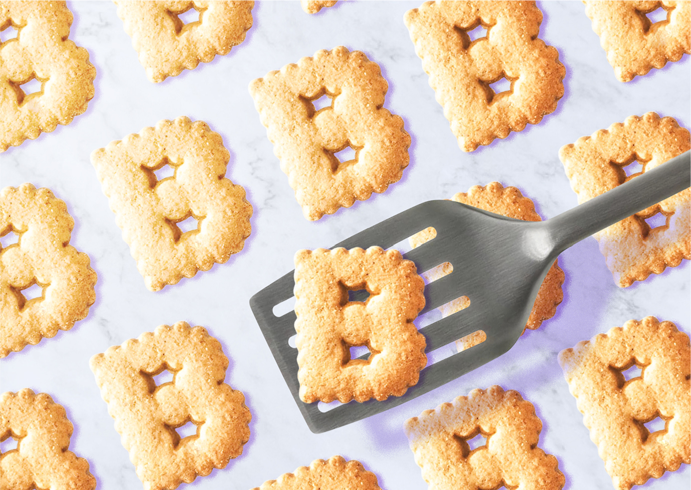 Photo of a group of consistent looking, B-shaped cookies with spatula.