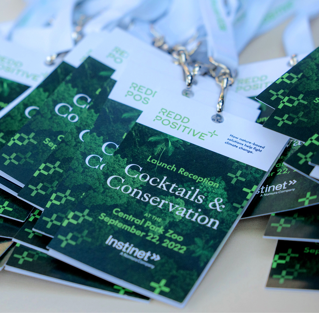REDD Positive Cocktails and Conservation launch event credentials stacked on a reception table.